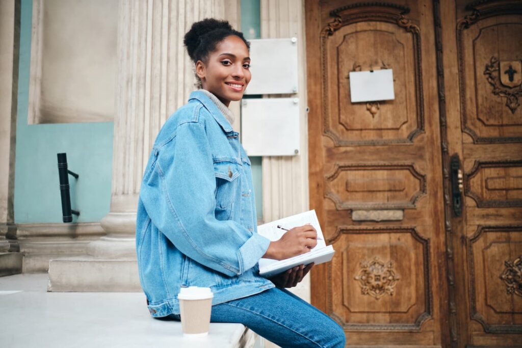 beautiful-smiling-casual-african-american-student-girl-in-denim-jacket-with-notebook-joyfully-looking-in-camera-outdoor (1)