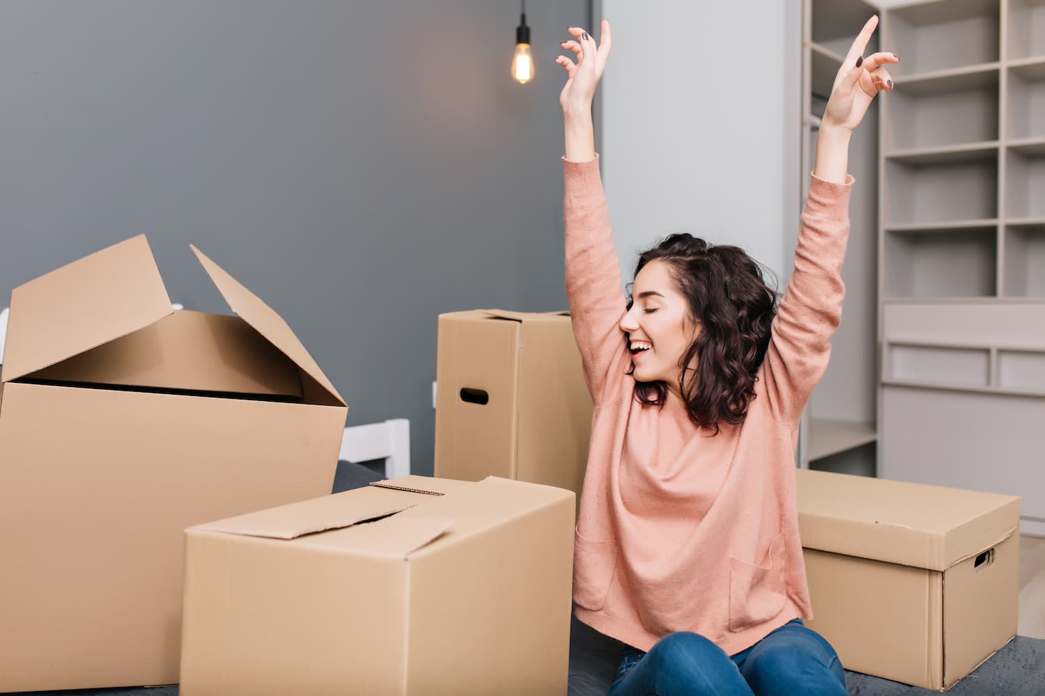 expressing-brightful-true-emotions-positivity-of-young-pretty-woman-with-short-brunette-curly-hair-on-bed-surround-carton-boxes-in-modern-apartment-enjoying-moving-happiness-at-new-home (1)