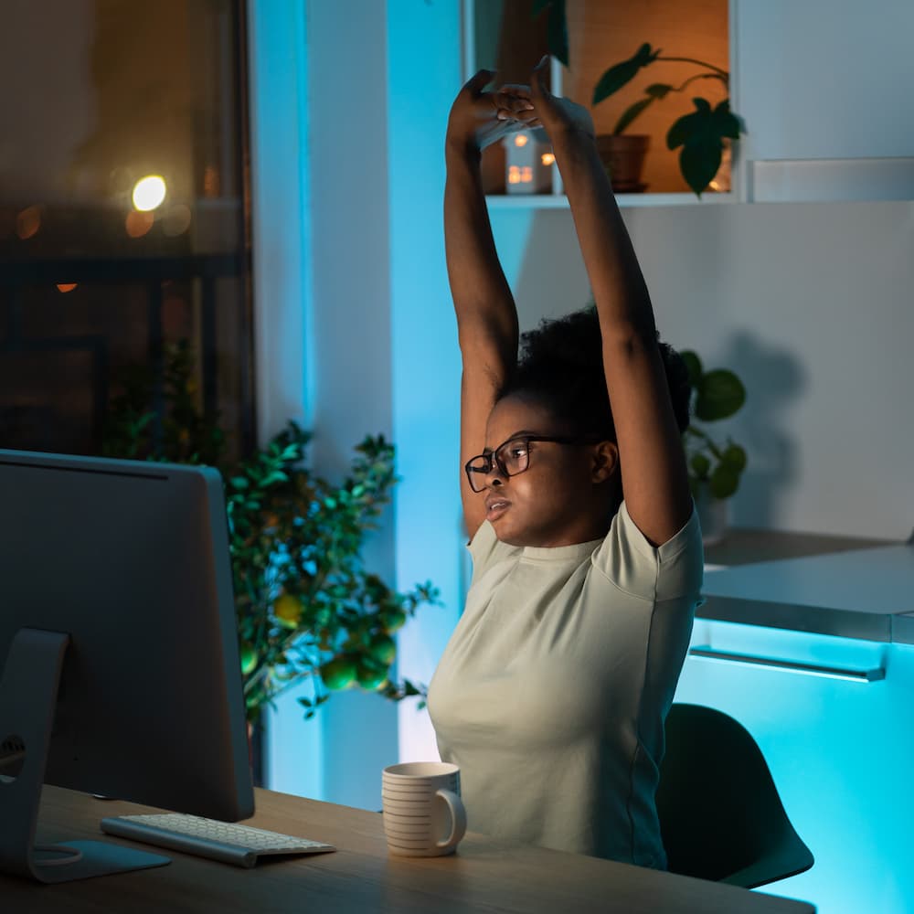 tired-african-young-woman-takes-a-break-from-work-on-computer-at-home-does-exercise-and-stretching (1)